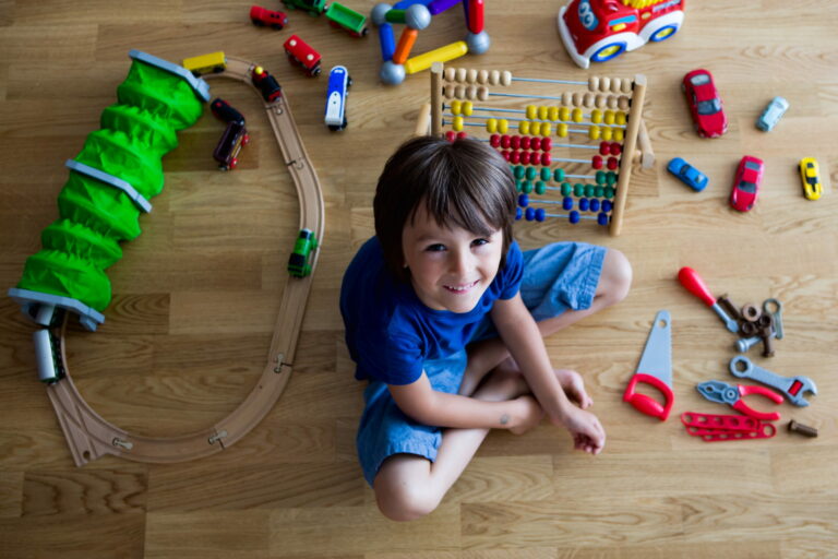 Jeune garçon jouant avec des jouets dans une chambre